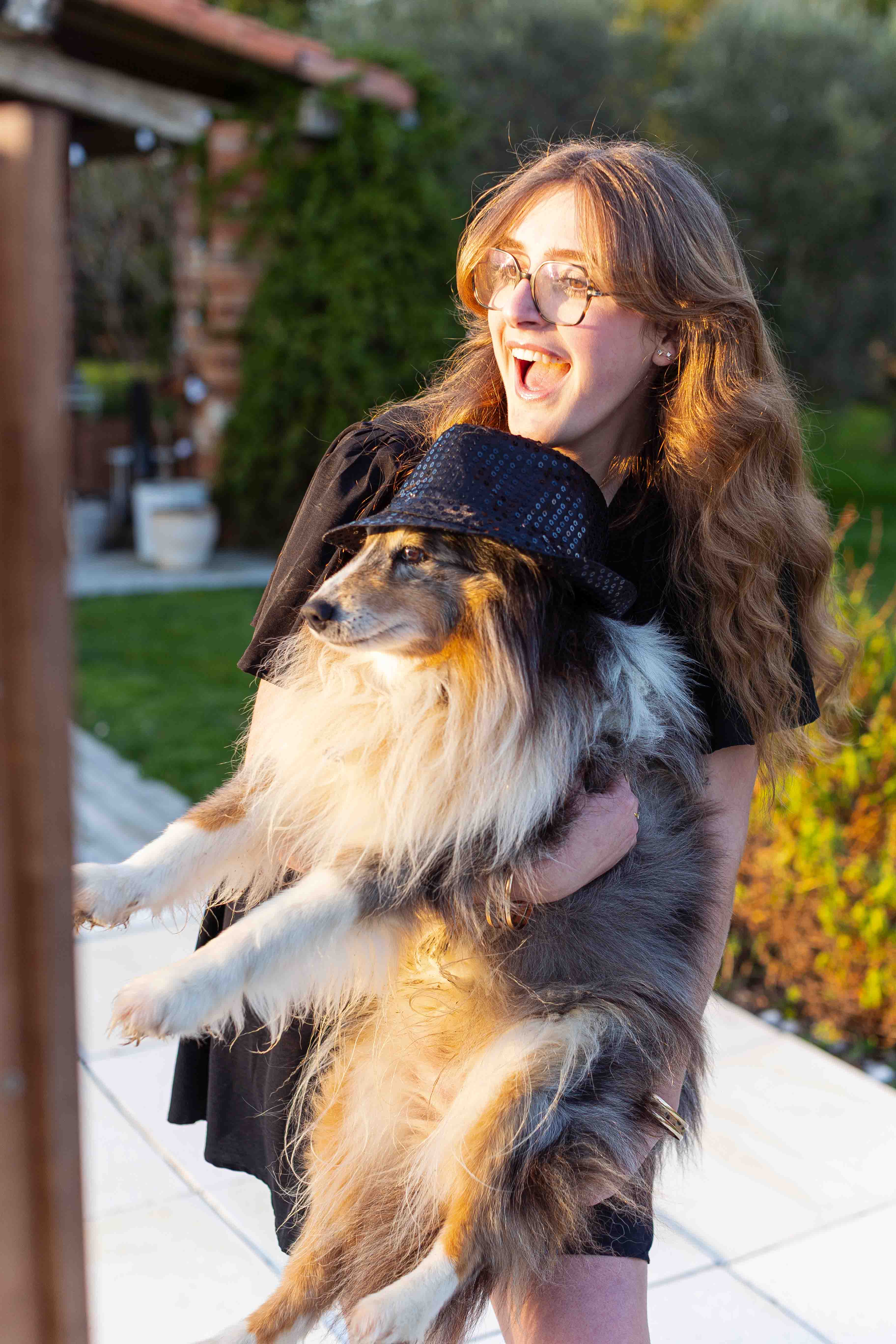 Invitée riant avec son chien devant la borne, lumière dorée